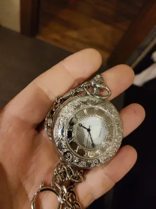 Reloj de bolsillo plateado con cadena
