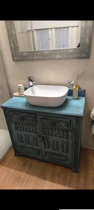 Mueble de baño azul con lavabo y grifo