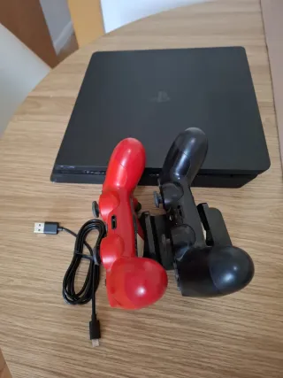 PS4 con 2 mandos, base carga y 2 juegos