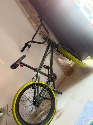 Bicicleta BMX verde con ruedas amarillas