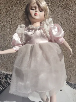 Muñeca de porcelana con vestido blanco
