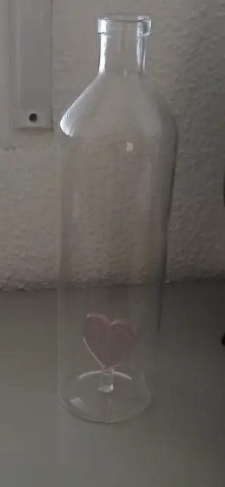 Botella de cristal con corazón rosa
