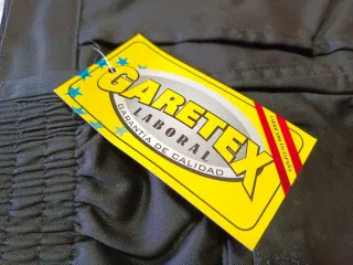 Pantalones de trabajo negros con detalles rojos.