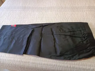 Pantalones de trabajo negros con detalles rojos.