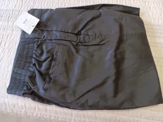 Pantalones de trabajo negros con detalles rojos.