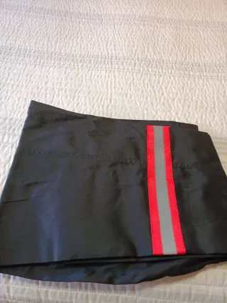 Pantalones de trabajo negros con detalles rojos.