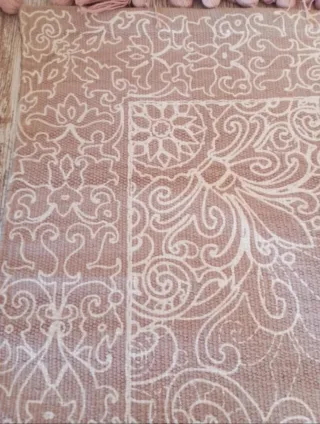 Alfombra beige con flecos rosas