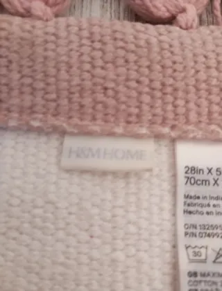 Alfombra beige con flecos rosas