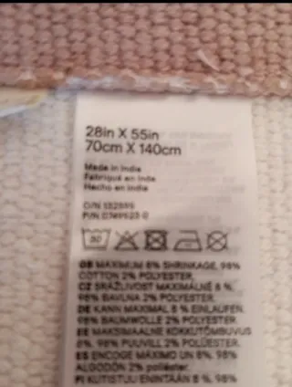 Alfombra beige con flecos rosas