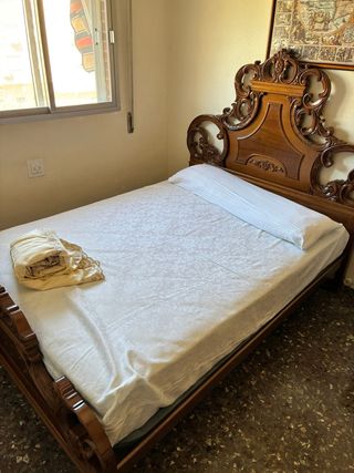 Cama de madera con cabecero tallado