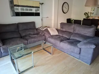 Sofá modular gris con mesa de cristal