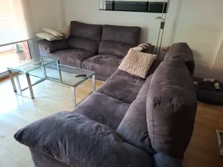 Sofá modular gris con mesa de cristal