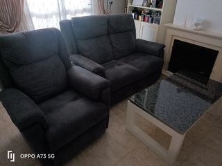 Mobiliario de salón con sofás y mesa elevable.