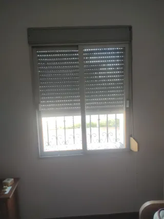 Ventana con rejas y persiana