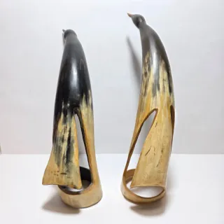 Due sculture a forma di uccelli in corno.