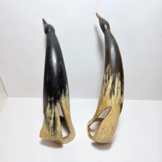 Due sculture a forma di uccelli in corno.