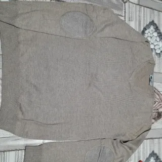 Maglione beige con toppe sui gomiti e collo a V.