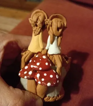 Figurita de barro con setas