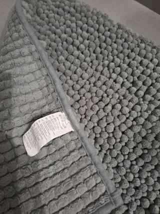 Alfombra de baño gris.