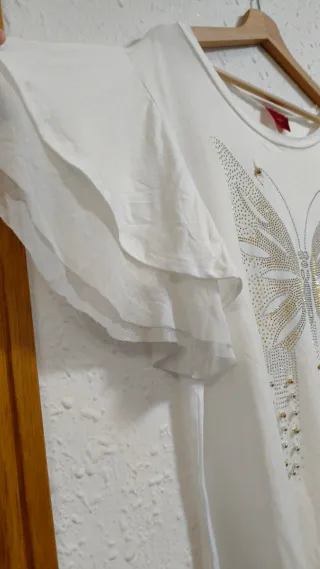 Blusa blanca fluida con mariposa en tachuelas