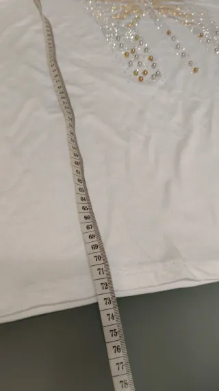 Blusa blanca fluida con mariposa en tachuelas