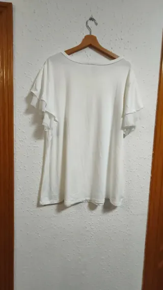 Blusa blanca fluida con mariposa en tachuelas