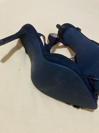 Zapatos de salón negros con adorno.