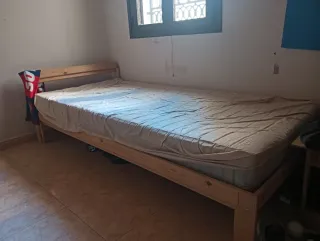 Cama individual de madera con colchón.