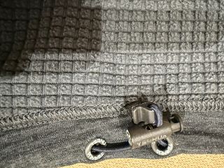 Chaqueta Ternua con capucha gris y detalles rojos