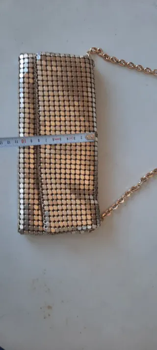 Bolso de mano dorado con cadena