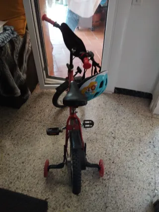 Bicicleta infantil roja con ruedines