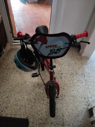 Bicicleta infantil roja con ruedines