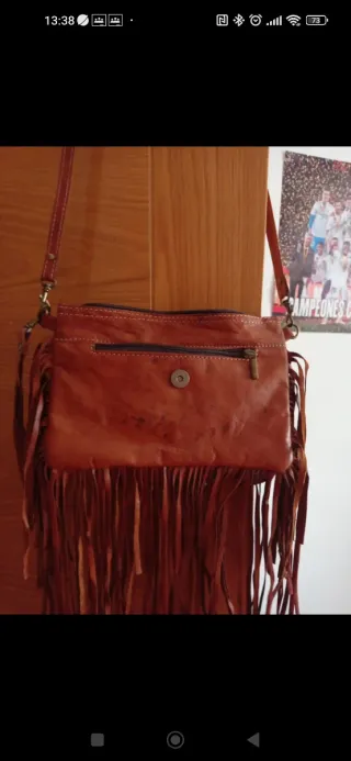 Bolso de cuero marrón con flecos y tachuelas
