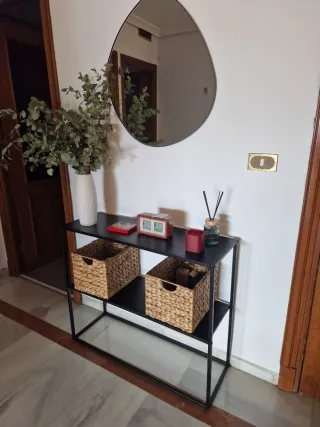 Recibidor y espejo metálicos negros.