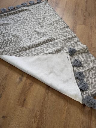 Alfombra gris con borlas estilo boho