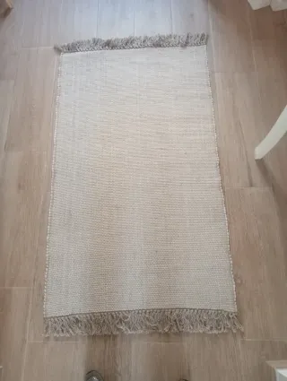 Alfombra beige de tela con flecos