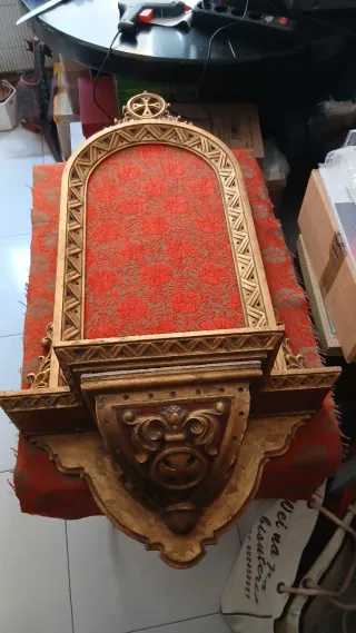 Antigua hornacina dorada con tela roja