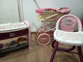 Cochecito de muñecas rosa con encaje y demás.