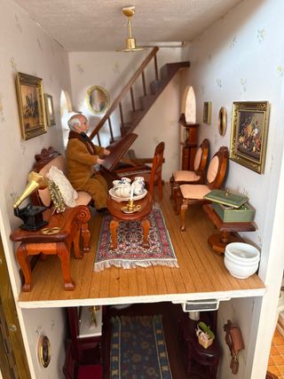 Casa de muñecas amarilla con iluminación