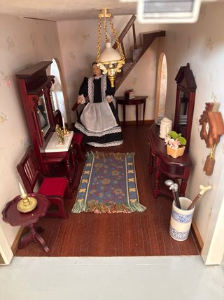 Casa de muñecas amarilla con iluminación