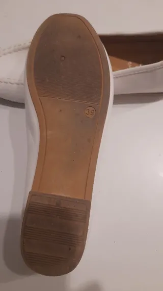 Zapatos planos blancos con detalle dorado