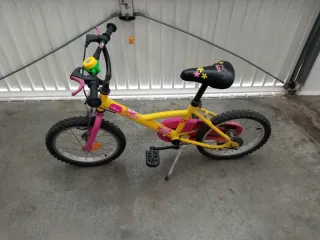 Bicicleta infantil amarilla con casco y accesorios