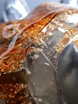 Lámpara dorada con tulipa de cristal soplado.