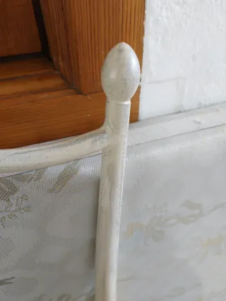 Cabecero de forja grisáceo.