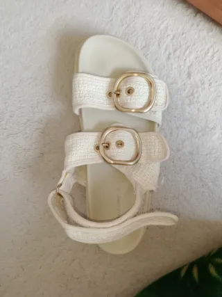 Sandalias de verano blancas con hebillas doradas