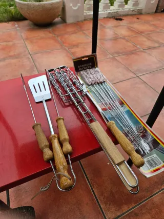 Barbacoa de jardín roja con utensilios