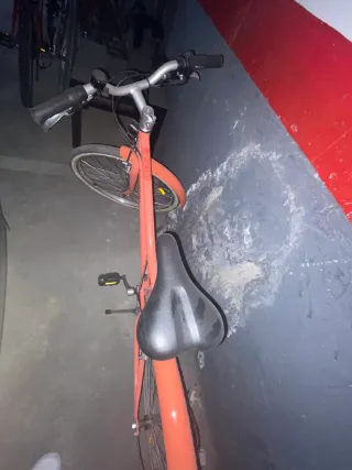 Bicicleta rosa coral con una luz delante