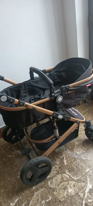 Carro de bebé negro y dorado