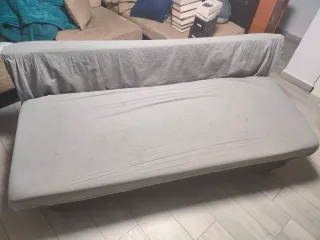 Sofá cama gris con desperfectos