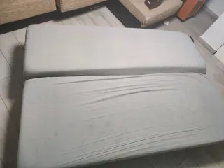 Sofá cama gris con desperfectos